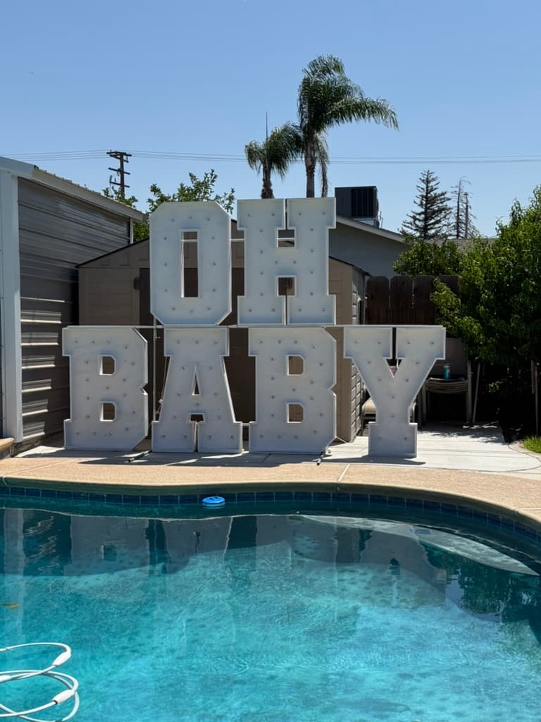 Oh baby marquee letters by a pool for a gender reveal