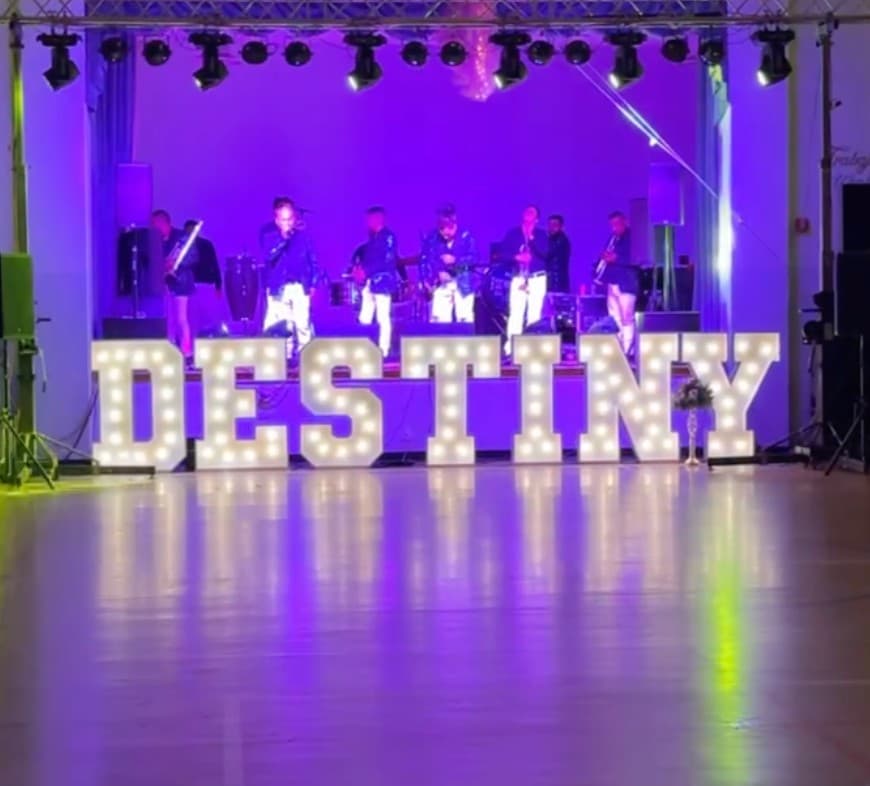 Destiny marquee letters on a dance floor with a live band at a quinceañera